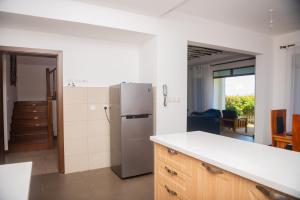 a kitchen with a stainless steel refrigerator in a room at Njakaimba Beachfront Villa. in Mombasa