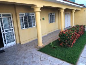 a house with columns and flowers in front of it at Hostel Vo Mariana in Goiânia