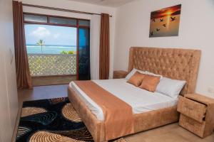 a bedroom with a bed with a view of the ocean at Njakaimba Beachfront Villa. in Mombasa