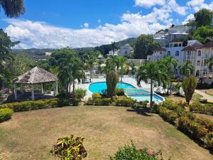 een grote tuin met een zwembad en een prieel bij Ivory Tower Ocho Rios in Ocho Rios