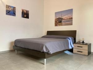 1 cama en un dormitorio con 2 cuadros en la pared en AL RUDERINO, en Comacchio