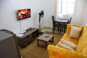 a living room with a yellow couch and a fireplace at Pacho by Jay in Kisumu