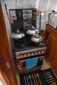 a stove with three pots on top of it at Pacho by Jay in Kisumu