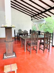 uma sala de jantar com uma mesa e cadeiras e um fogão em Peacock Villa Resort em Udawalawe