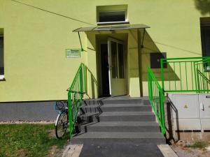 eine Treppe, die zu einem gelben Gebäude mit einer Tür führt in der Unterkunft Penzion ČESKÁ FARMA in Vysoké Mýto