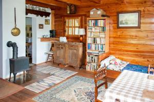 a living room with wooden walls and a book shelf at Kalinowa Chata in Wierchomla Wielka