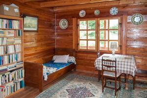 a room with a bed and a table and a book shelf at Kalinowa Chata in Wierchomla Wielka