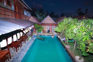 a swimming pool in a yard with chairs and a house at Negombo The Nature Villa and Cabanas in Negombo