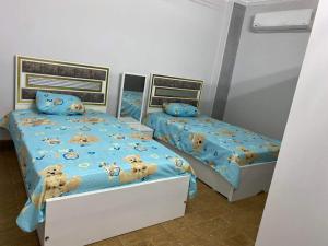 - une chambre avec 2 lits avec des ours en peluche sur les draps dans l'établissement شقة 9 شارع الصفاء / طه حسين / النزهة الجديدة, au Caire