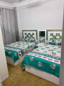 - 2 lits installés l'un à côté de l'autre dans une chambre dans l'établissement شقة 9 شارع الصفاء / طه حسين / النزهة الجديدة, au Caire