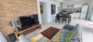 a living room with a couch and a flat screen tv at Villa Paradise in Chaweng