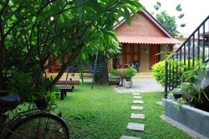 a garden with a bench and a house at Negombo The Nature Villa and Cabanas in Negombo