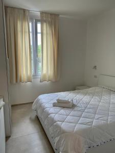 - une chambre blanche avec un lit et une fenêtre dans l'établissement Casa San Michele, à Sassuolo