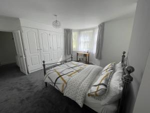 a bedroom with a bed with white walls and a window at Garden flat in 'Little Chelsea' in Eastbourne