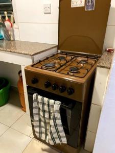 una cocina con fogones y una toalla en el horno en Cottage with AC, en Kisumu