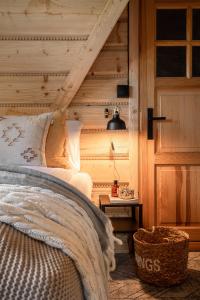a bedroom with a bed and a wooden wall at Dom Górski 878 mnpm in Zakopane