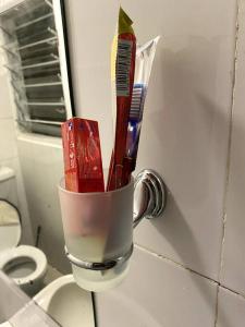 a cup with toothbrushes and toothpaste in a bathroom at Cottage with AC in Kisumu
