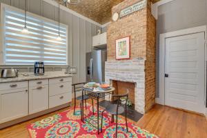 a kitchen with a brick fireplace and a table at Welcoming Norcross Cottage with Deck and Shared Grill! in Norcross