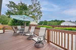 a deck with a table and chairs and an umbrella at Welcoming Norcross Cottage with Deck and Shared Grill! in Norcross