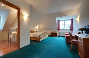 um quarto com uma cama e uma televisão num quarto em Hotel Sachsenklemme em Fortezza