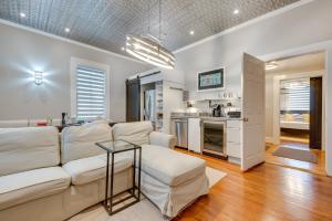 a living room with a white couch and a kitchen at Cozy and Modern Norcross Hideaway with Covered Porches in Norcross