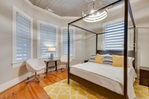a bedroom with a bed and a desk and windows at Cozy and Modern Norcross Hideaway with Covered Porches in Norcross