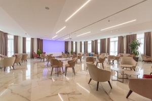 una grande stanza con tavoli e sedie e schermo viola di Hotel Terme Paradiso ad Abano Terme