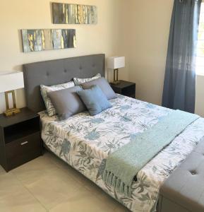 a bedroom with a bed with two night stands and two lamps at Yaad Oasis in Discovery Bay