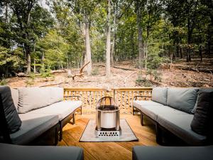 a patio with couches and a fire pit on a deck at Mtn Views - Sauna - Hot Tub - Health - Wellness in Massanutten