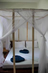 Una cama con sábanas blancas y almohadas azules. en Pamoja Beach Stays Hotel in Jambiani, en Jambiani