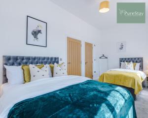 a bedroom with a bed with a blue and white comforter at Stunning Central House By PureStay Short Lets & Serviced Accommodation Birmingham in Birmingham