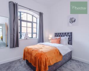 a bedroom with a bed with an orange blanket on it at Stunning Central House By PureStay Short Lets & Serviced Accommodation Birmingham in Birmingham