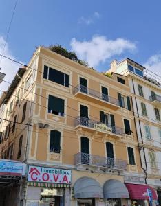 ein gelbes Gebäude mit Balkon in einer Stadtstraße in der Unterkunft Les Chambres de la Place in Sanremo