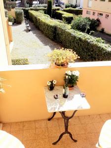 uma pequena mesa numa varanda com flores em La Victoire em Fréjus