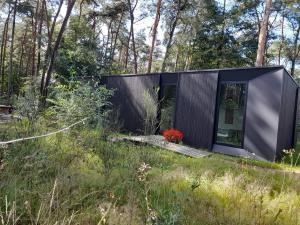 a black house in a field with trees at Black Box in Lille