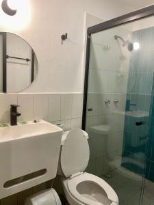 a bathroom with a toilet and a sink and a shower at Moloch Hostel & Suites in Cancún