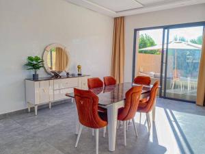 マラケシュにあるArgan Golf Villa 4-bed Marrakechのダイニングルーム(テーブル、椅子、鏡付)