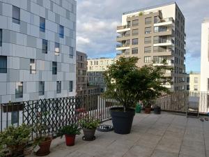 einen Balkon mit Topfpflanzen und Gebäuden in der Unterkunft chambre d'hôte / B&B Massy 1 minute gare TGC/RER in Massy