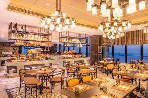 金沙萨Hilton Kinshasa的有桌椅和酒吧的餐厅
