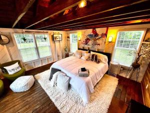 a bedroom with a large bed in a room with windows at Tiny House Hideaway with King Bed in Cape Charles