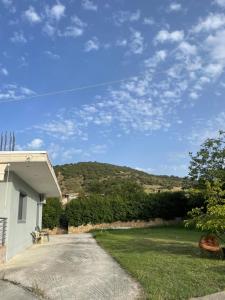 a driveway leading to a house with a mountain in the background at Margaret home in Kalývia