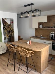 a kitchen with a wooden table and two chairs at L'annexe 