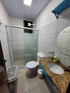een badkamer met een wastafel, een toilet en een douche bij Itacimirim village pé na areia in Itacimirim