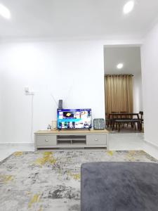 sala de estar con TV de pantalla plana sobre una mesa en Singgah Homestay en Kuala Terengganu