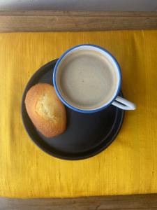 a cup of coffee and a donut on a plate at Flowers By Yasmine Trouville in Trouville-sur-Mer