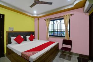 a bedroom with a bed and a window and a chair at Hotel Mahal And Restaurant Kanchrapara in Kolkata