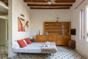 a bedroom with a bed and a wooden dresser at Lodging Apartments Paseo de Gracia in Barcelona