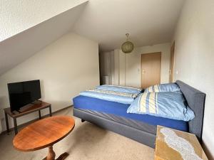 a small bedroom with a bed and a table at Mitten in Detmold mit schönem Ausblick in Detmold