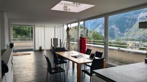 Zimmer mit einem Tisch und Stühlen sowie einem großen Fenster in der Unterkunft Vesmira_1 in Chur
