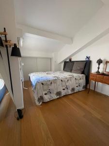 1 dormitorio con 1 cama y suelo de madera en Colourful loft in Marseille, en Marsella